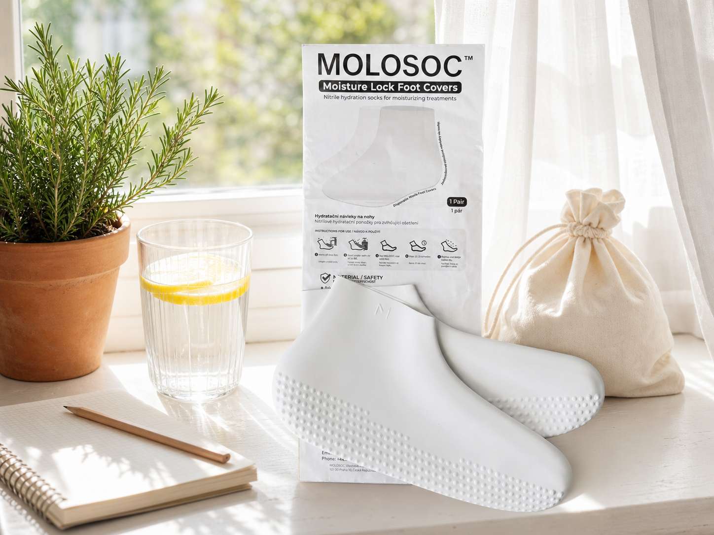 Molosoc foot covers and packaging styled on a sunlit windowsill with a plant and a glass of water
