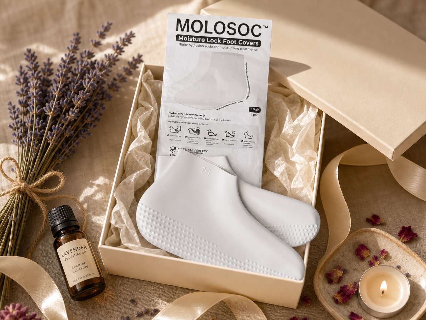 An open gift box with a pair of Molosoc foot covers, lavender oil, and dried lavender sprigs styled around it